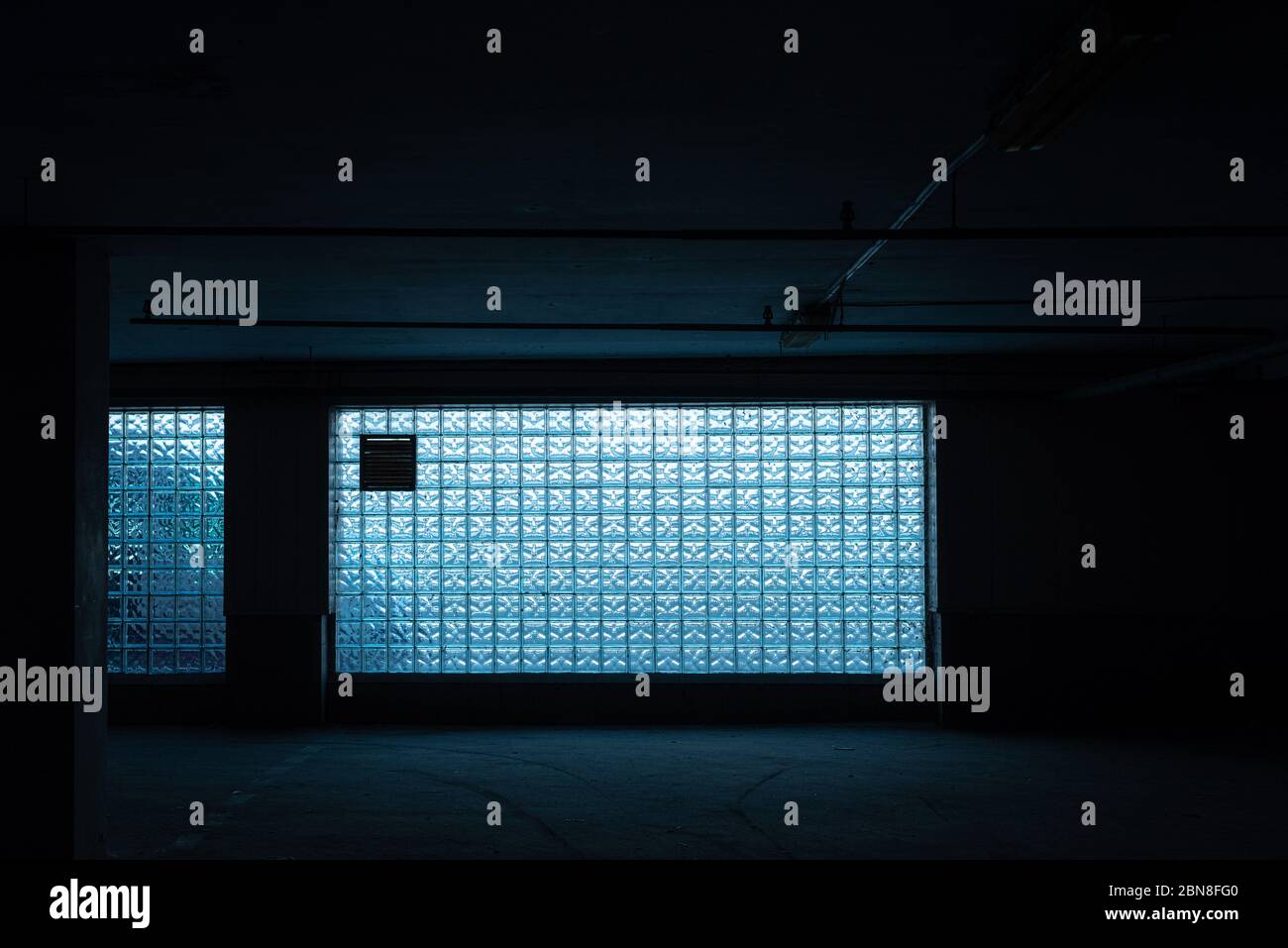 pared de ladrillo de vidrio azul - textura sin costuras. color abstracción en pared de cristal de ladrillo. Habitación oscura con una gran ventana de ladrillos de vidrio. Foto de stock