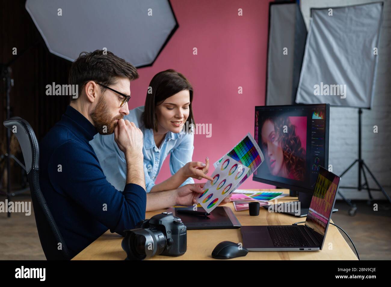 Los socios discuten en el trabajo. Fotógrafo profesional y retoucher.  Retoque de imágenes. Trabajo en equipo en un estudio fotográfico  profesional Fotografía de stock - Alamy