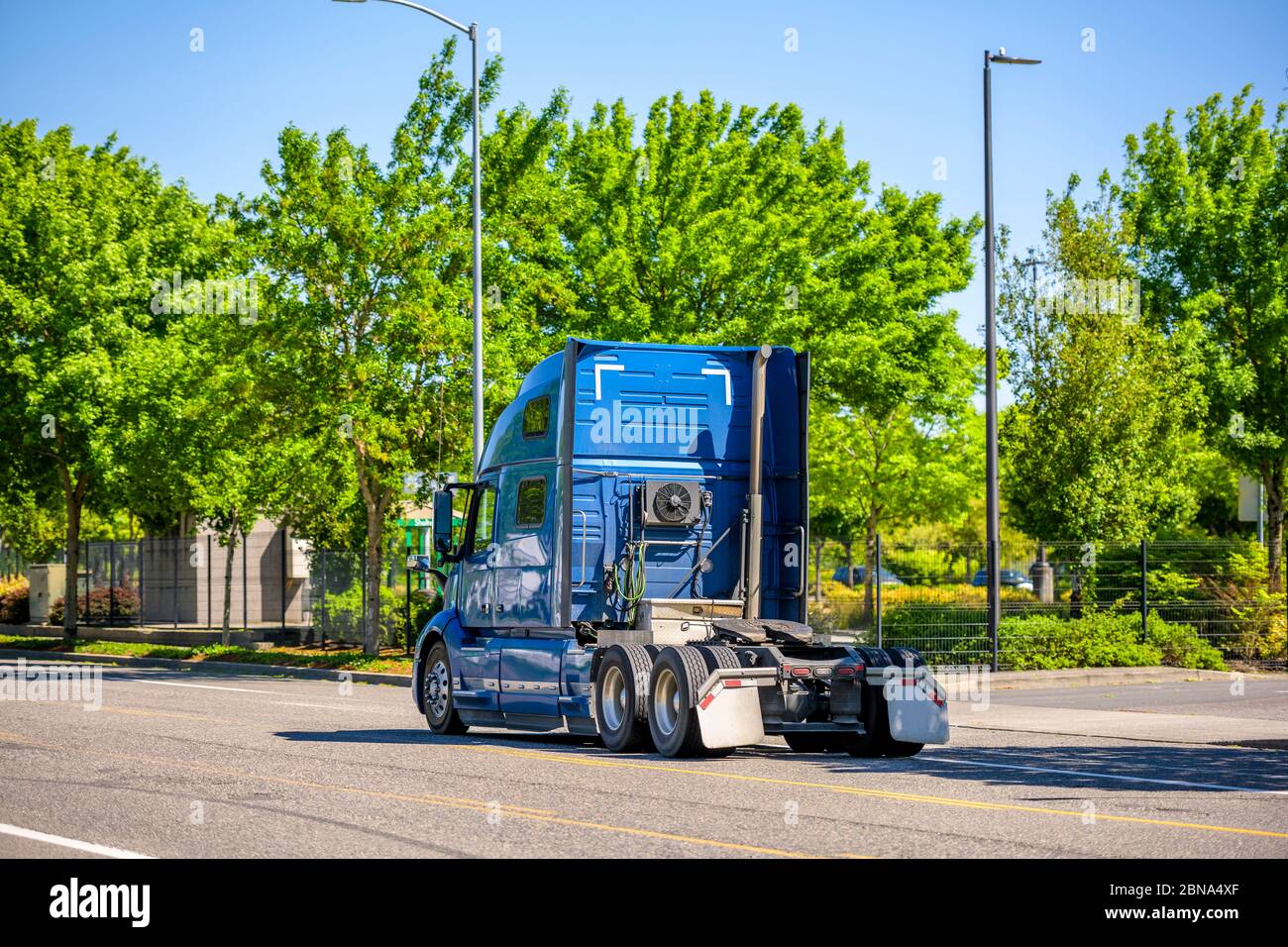 Blue gran equipo de largo recorrido semivolutraje tractor con compartimento  para dormir para el conductor de camiones descanso corriendo en la calle  verde de la ciudad para recoger el cargado Fotografía de