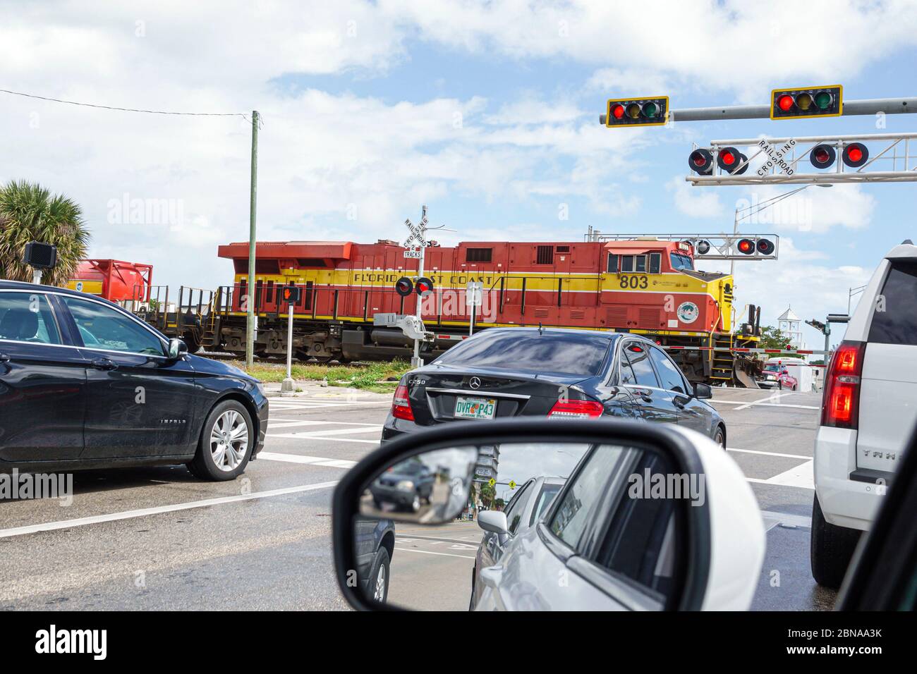 Miami Florida, las puertas del cruce del ferrocarril por el tren que pasa, los vehículos de tráfico parado los coches que esperan, East Coast Railway, locomotora roja, los visitantes viajan trave Foto de stock