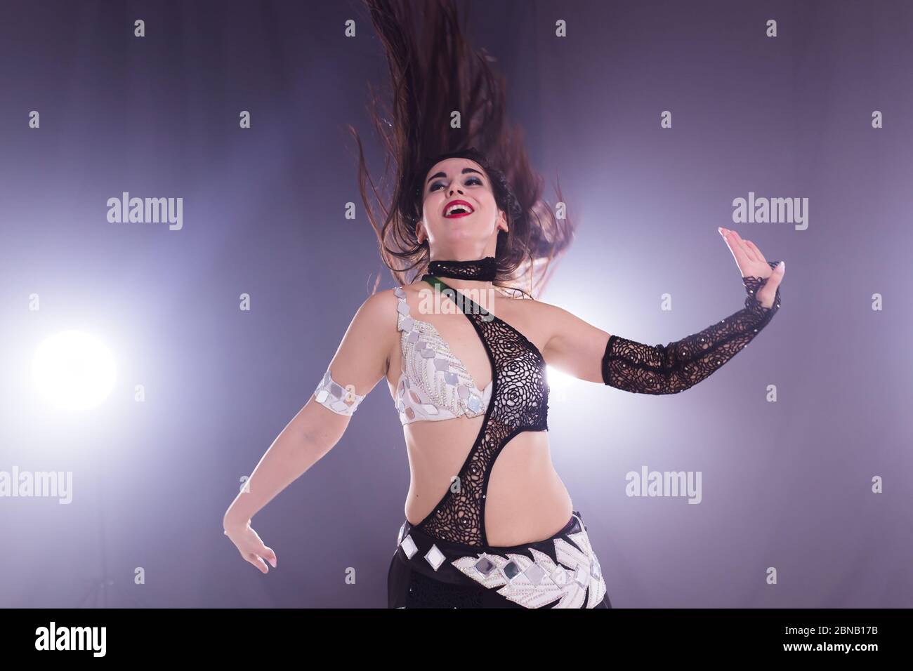 Bailarina de danza del vientre con velo rojo los brazos extendidos en un  escenario tropical Fotografía de stock - Alamy