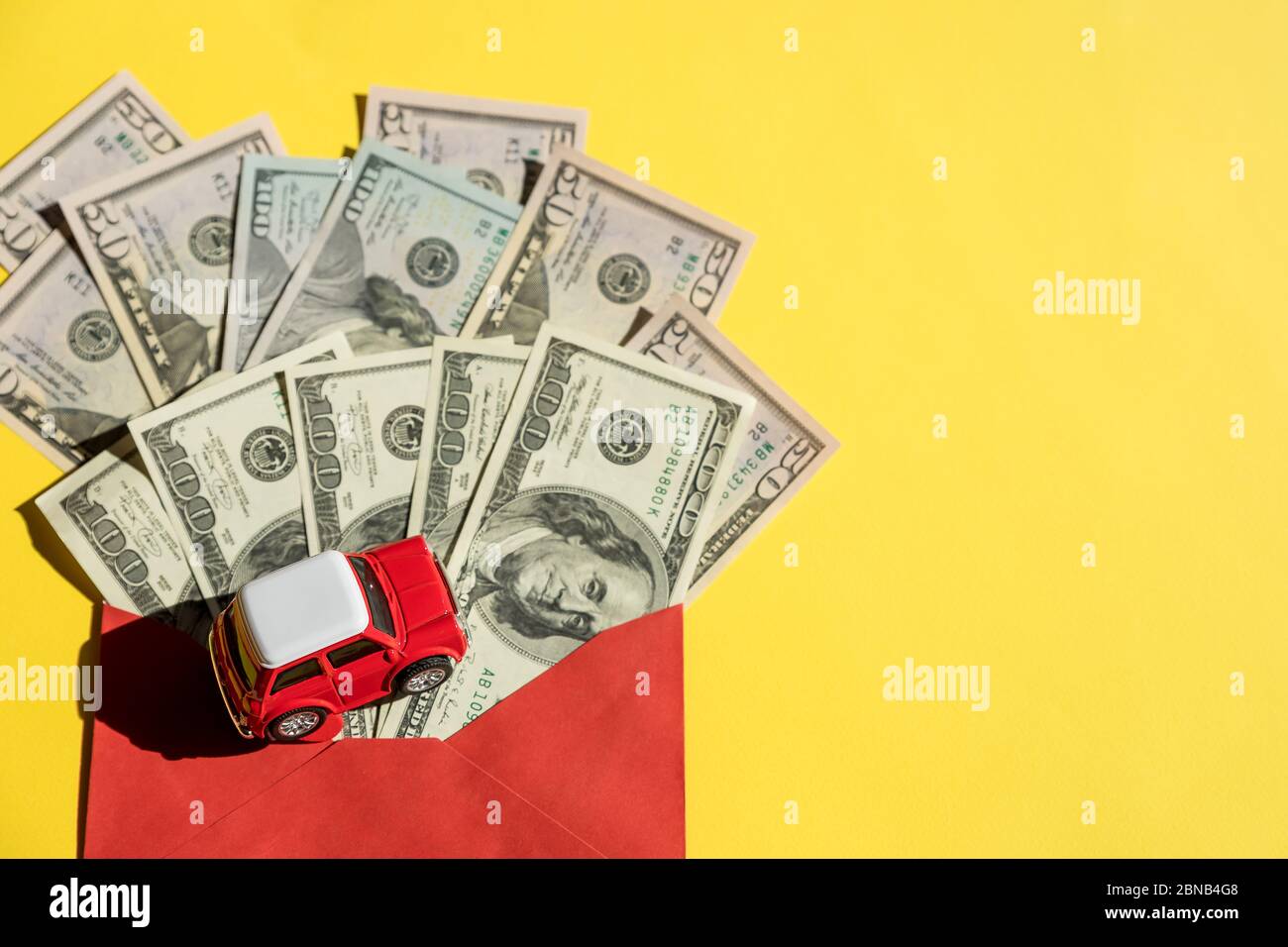 Modelo de coche y billetes de EE.UU., moneda. Préstamo de coche, financiero, ahorro de dinero, seguros y tiempo de leasing Concepts.toy coche rojo y un bote de dinero dólares facturas Foto de stock
