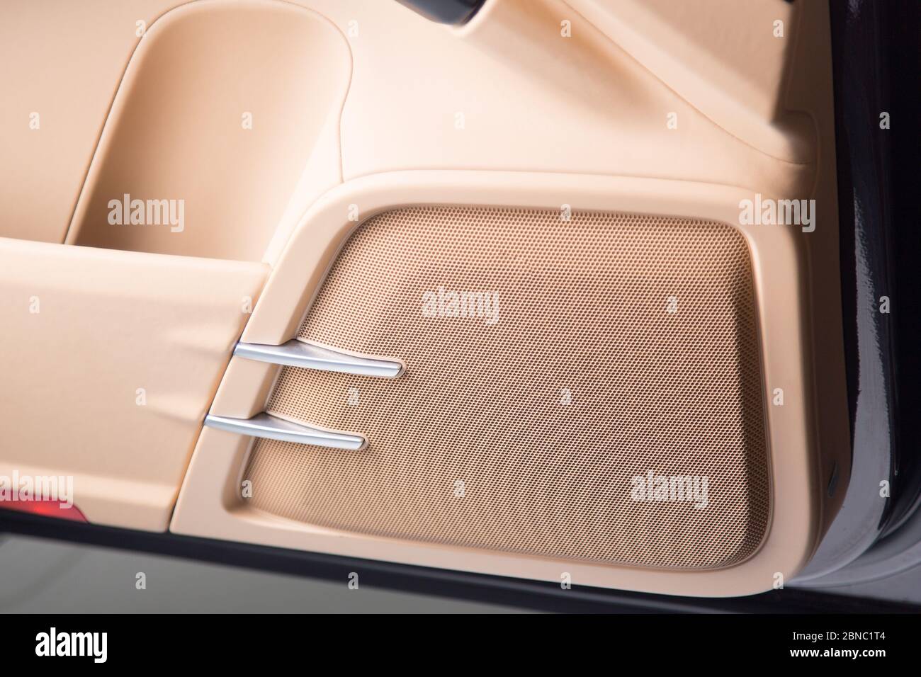 Primer plano de un altavoz beige de un coche de lujo moderno bajo las luces Foto de stock