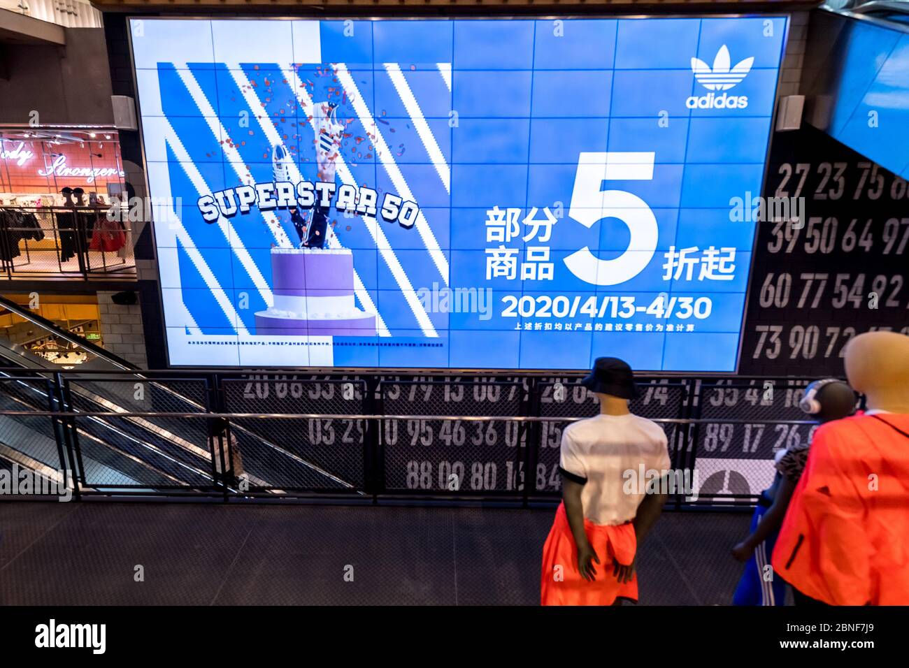 La vista interior de los clientes que seleccionan y compran productos en  una tienda Adidas, que lanza un 50% de descuento en la promoción, Shanghai,  China, 24 de abril de 2020. *