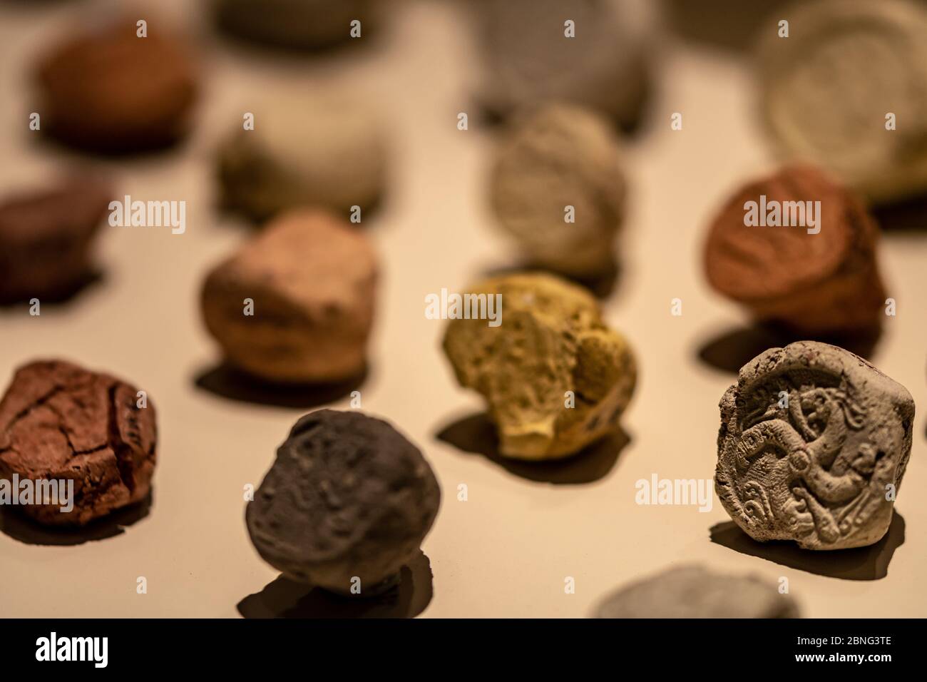 Primer plano de una colección de pequeñas piedras antiguas con talladas símbolos Foto de stock