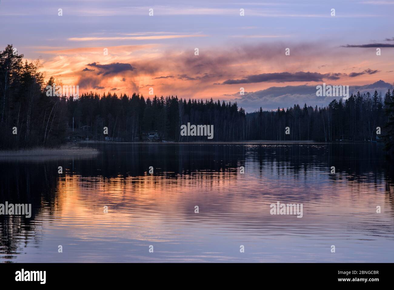 Paisaje pintoresco del lago con ambiente de tranquilidad, puesta de sol y hermosos reflejos en la noche de primavera en Finlandia Foto de stock