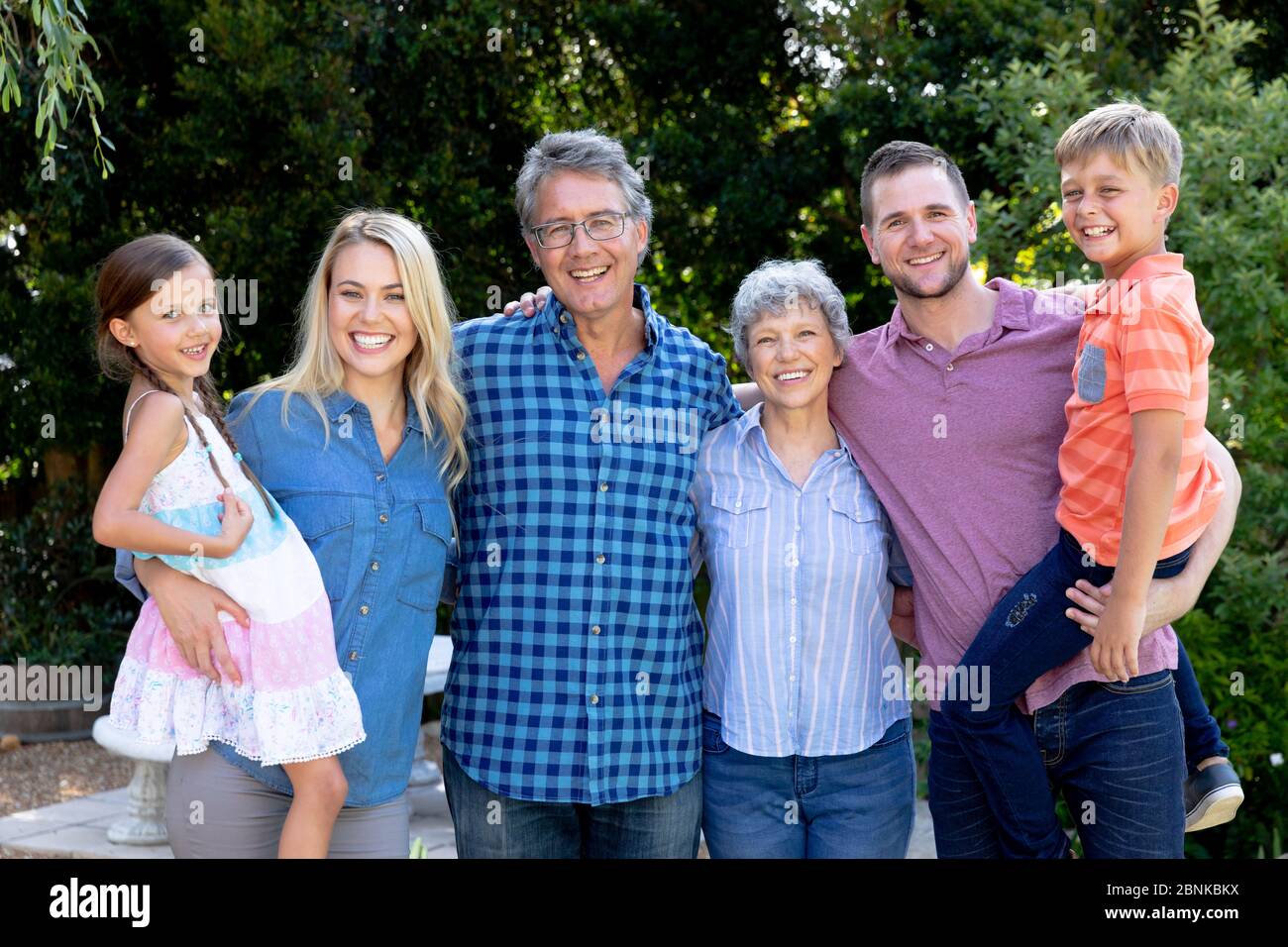 Familia caucásica de tres generaciones que pasan tiempo en su jardín Foto de stock