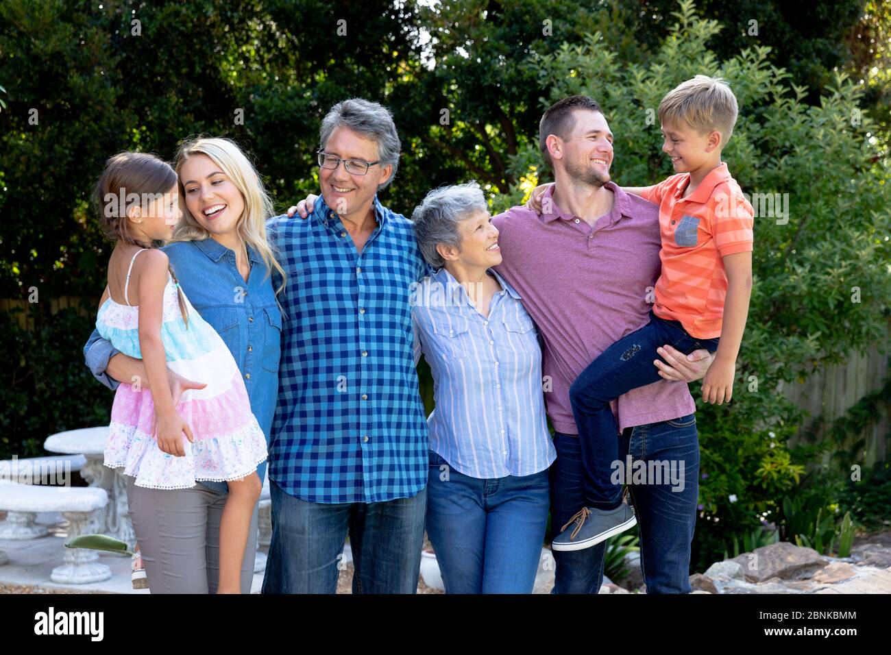 Familia caucásica de tres generaciones que pasan tiempo en su jardín Foto de stock
