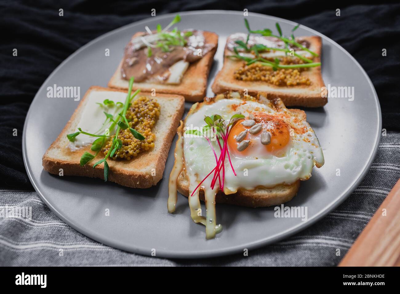 Variedad de bocadillos con pan de tartina huevo escalfado aguacate