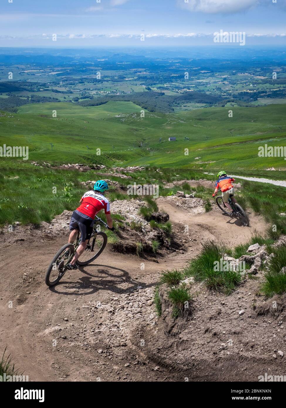 Ciclistas de montaña cerca del pueblo de Super Besse, descenso en el parque de bicicletas de Superbesseim Massif Central, en la Auvernia en Francia. Salida cerca del Puy de Sancy Foto de stock