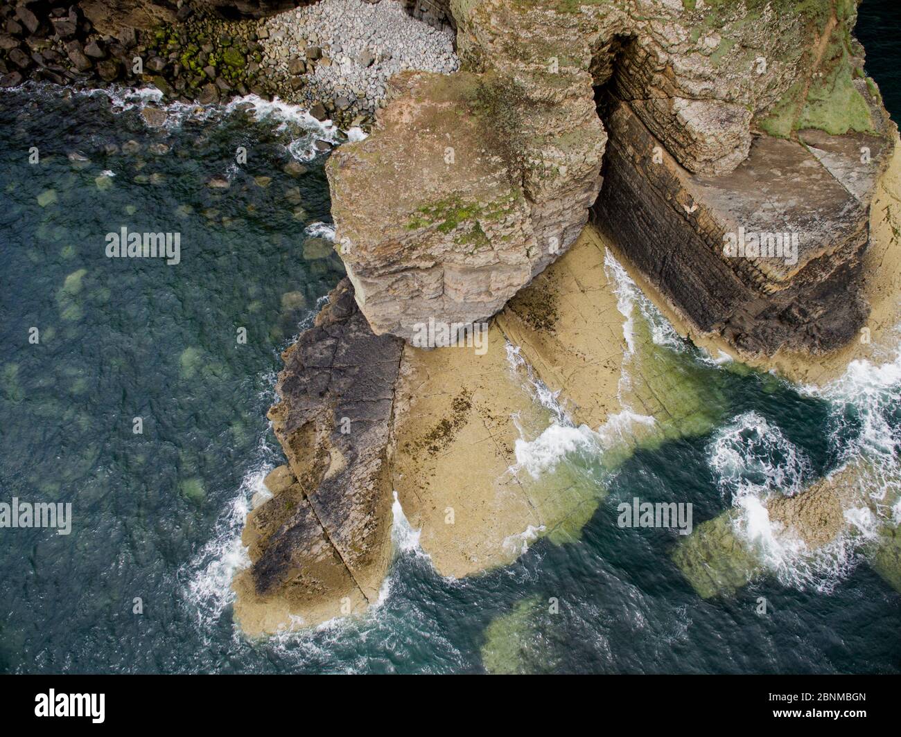 Vista aérea de plataforma de corte de olas en rocas sedimentarias de edad Ordovicia en Trwyn Wylfa, Abersoch, Gales, Reino Unido. Las olas han explotado un fuerte lecho Foto de stock
