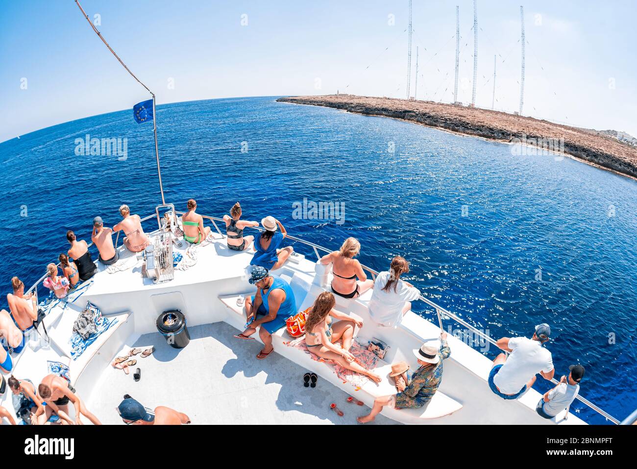 AYIA Napa, CHIPRE - 10 de agosto de 2019: Barco de excursión lleno de turistas navega por la Península del Cabo Greco. Foto de stock