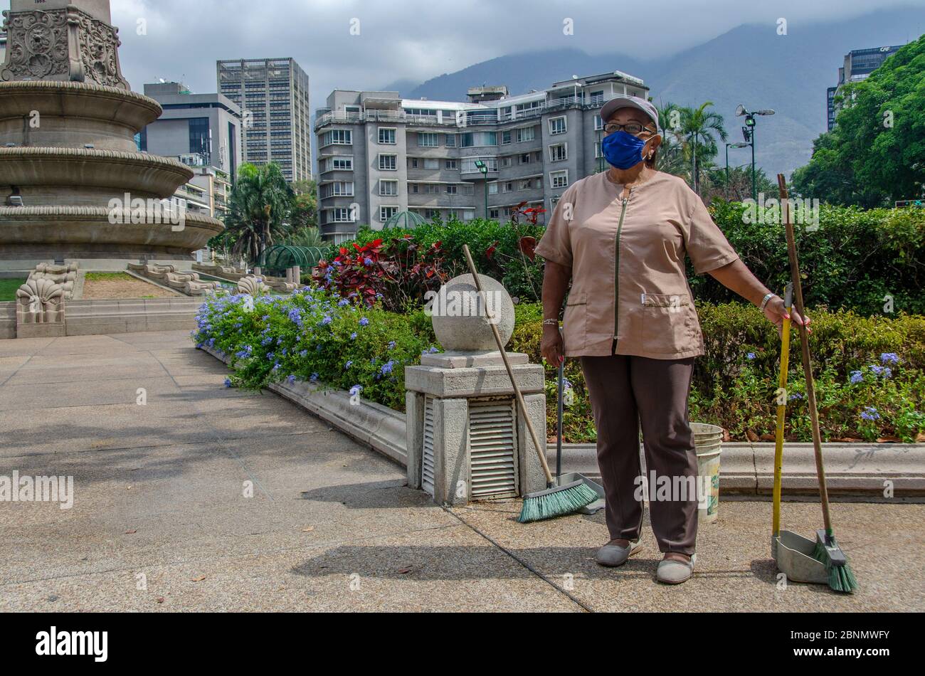 Carmen es una escoba que ha trabajado todos los días a pesar de la cuarentena, para mantener la Plaza Francia limpia y ordenada en Caracas Foto de stock