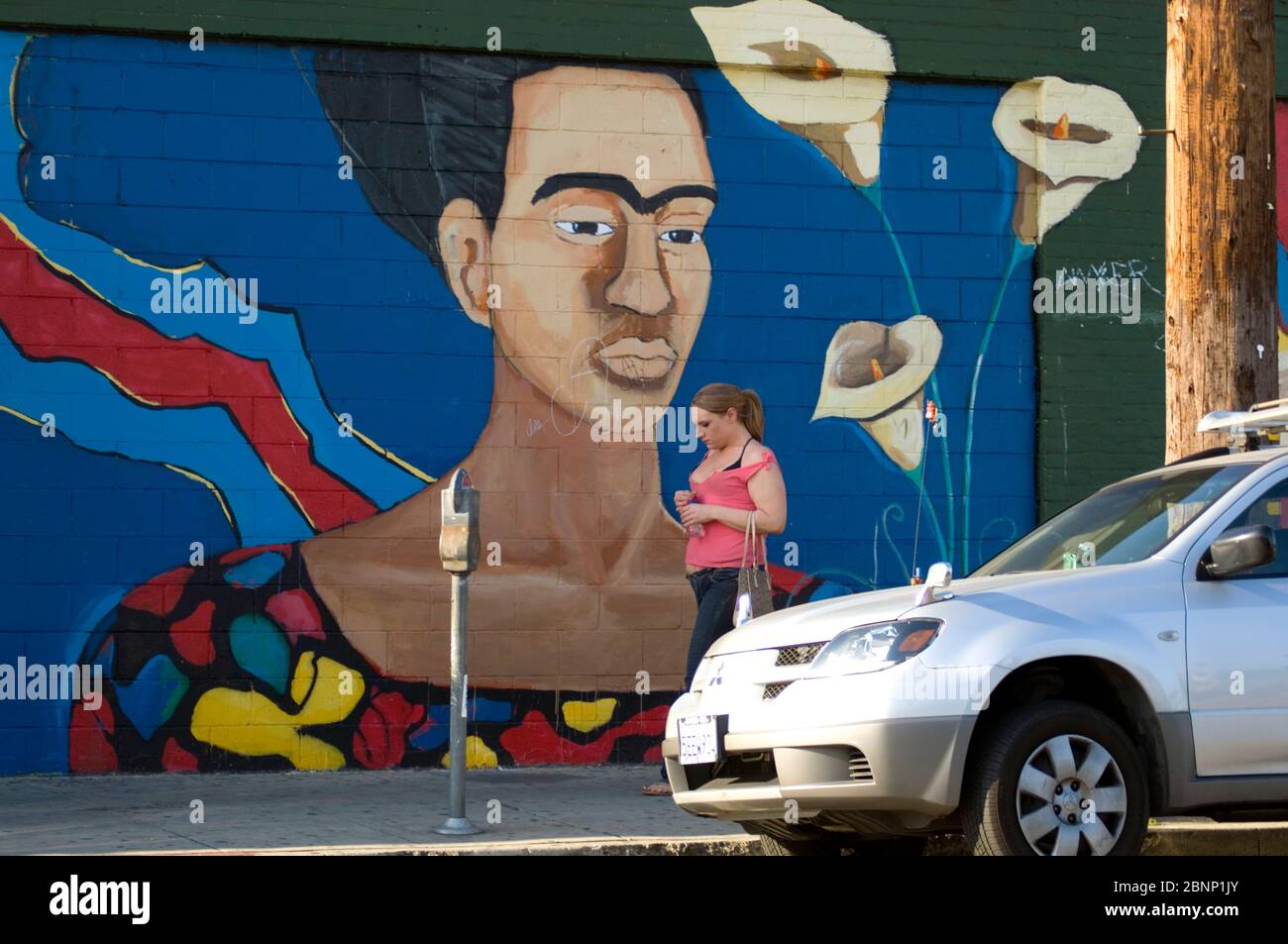 Una mujer pasa por un mural que representa a la artista mexicana Frida