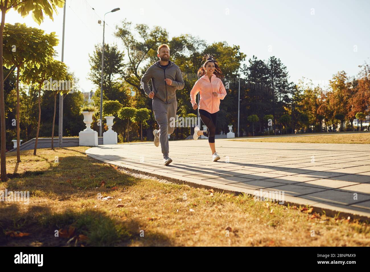 Hermosa pareja de fitness con ropa deportiva con estilo está posando en una  calle de la ciudad