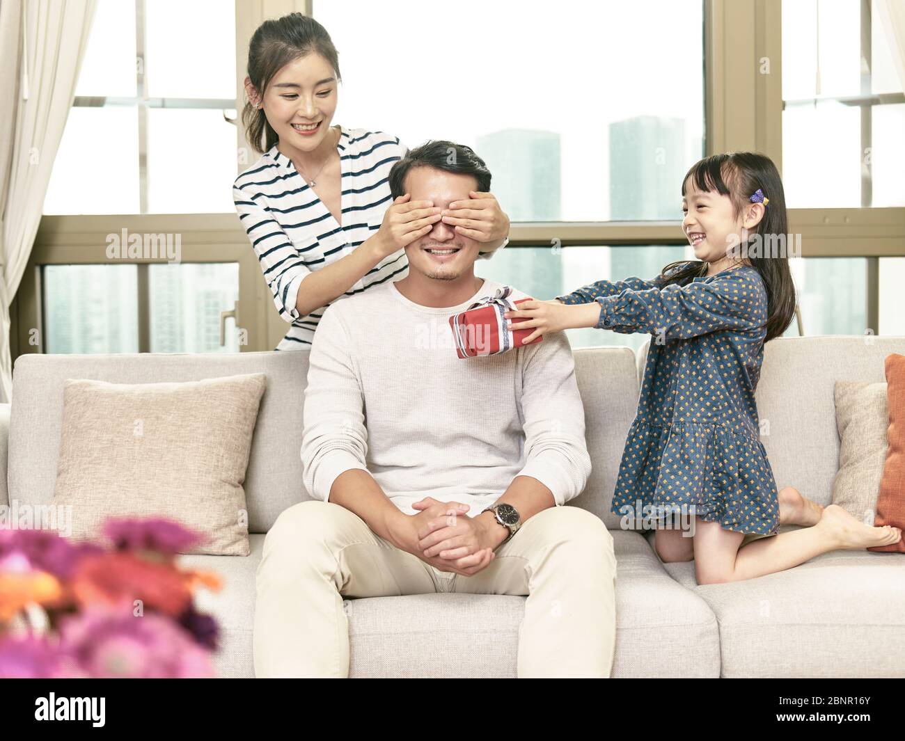 niña asiática dando a padre un regalo de cumpleaños Foto de stock