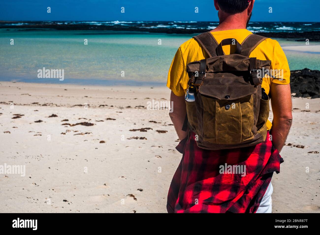 Vacaciones de verano gente viaje mochila concepto con el hombre parado y  mirando el agua azul del mar de la playa - arena blanca amarilla y  actividad al aire libre Fotografía de