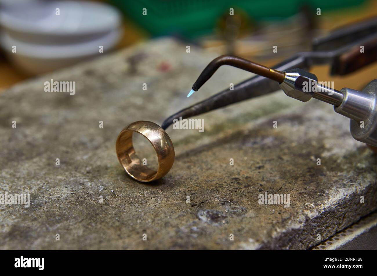 Producción de joyas. El joyero hace un anillo de oro. El proceso de  soldadura de oro con un quemador. Captura de detalles con poca profundidad  de campo Fotografía de stock - Alamy