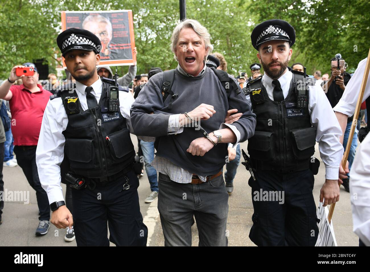 La policía apretón de manos y detiene a un manifestante en Hyde Park en Londres después de la introducción de medidas para sacar al país de su encierro. Foto de stock