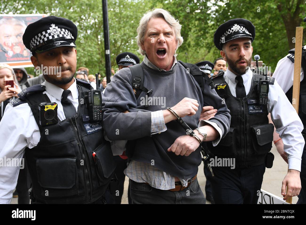 La policía apretón de manos y detiene a un manifestante en Hyde Park en Londres después de la introducción de medidas para sacar al país de su encierro. Foto de stock