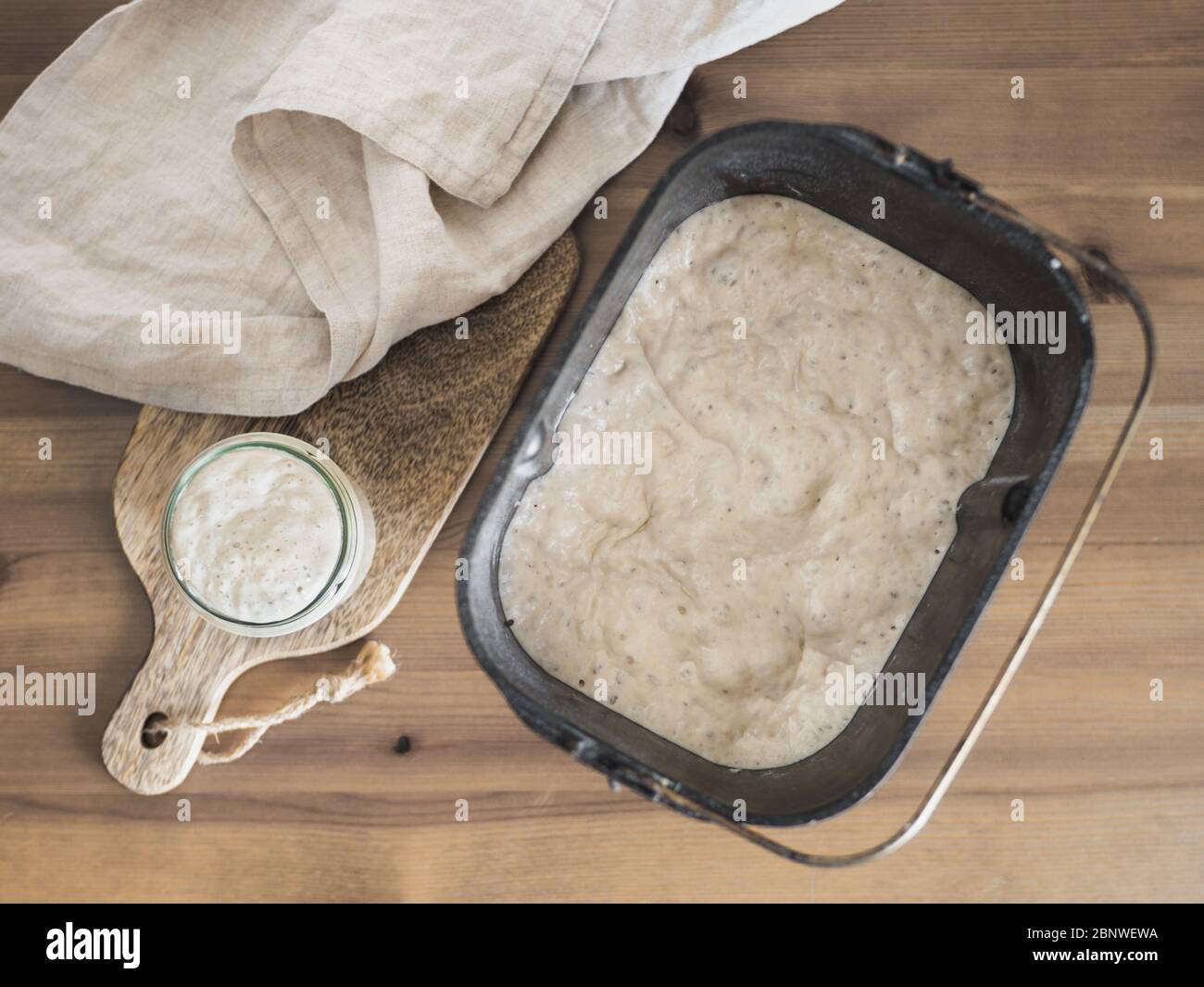 Masa fermentada de trigo en jarra de cristal y masa fermentada en pan de pan de máquina para hacer pan. Concepto de panificadora casera Foto de stock