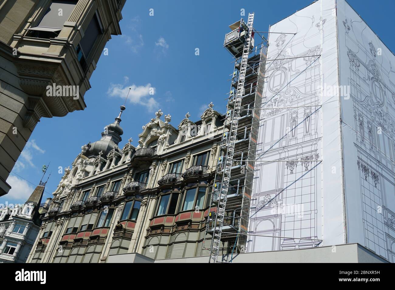 Centro histórico de la ciudad de Zurich en la reconstrucción, las fachadas de los edificios históricos están cubiertas por una gruesa red de protección blanca, vista lateral Foto de stock