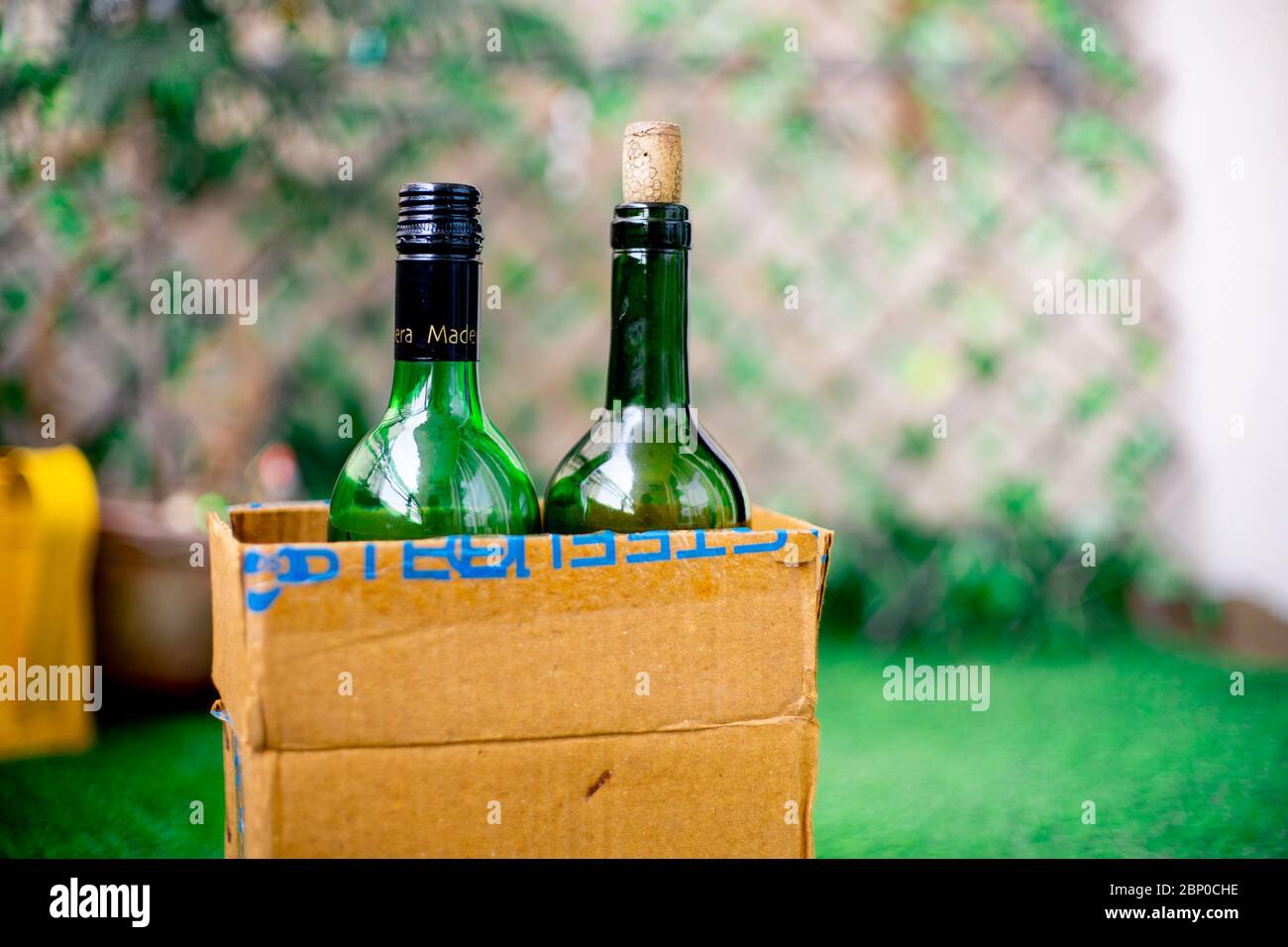 Botellas de alcohol de licor en una caja de cartón para llegar a casa  entregado en línea en el jardín en el umbral de una casa Fotografía de  stock - Alamy