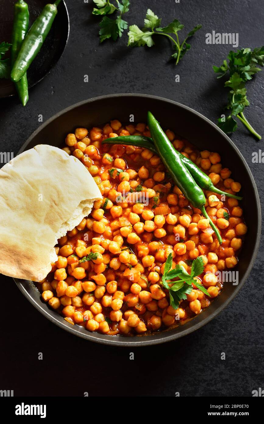 Garbanzos asados crujientes. Plato de estilo indio sobre fondo de piedra negra. Concepto de comida vegetariana vegetariana vegana. Foto de stock