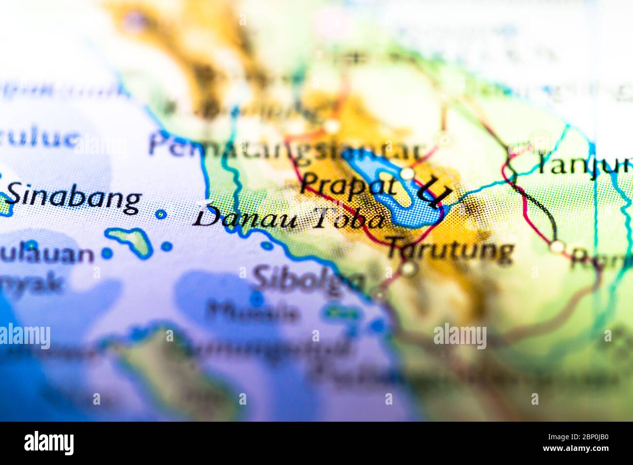 Profundidad reducida del campo se centra en la ubicación del mapa geográfico del lago Toba en el continente asiático de Indonesia en el atlas Foto de stock
