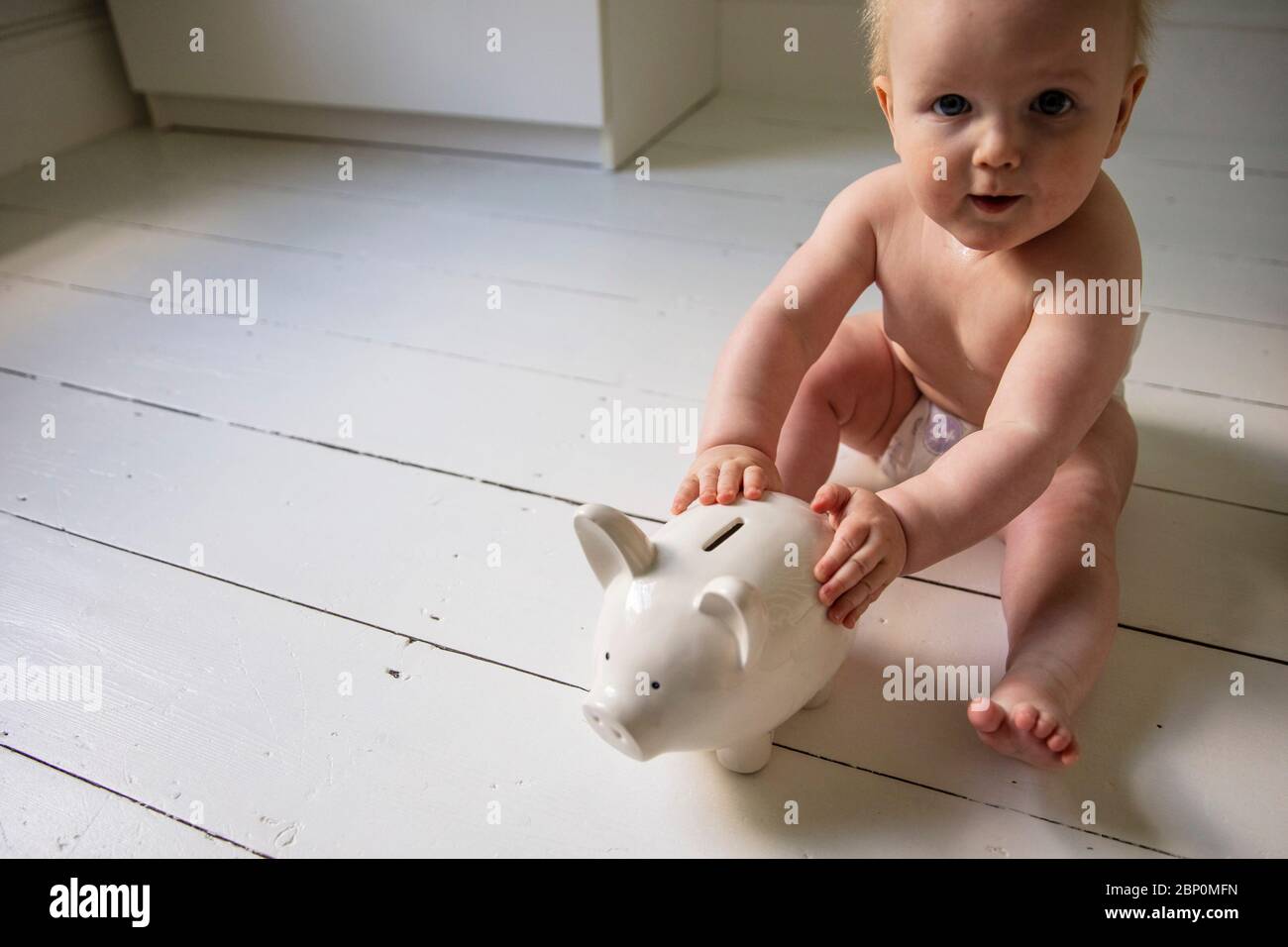Niño con un banco de pigmeo. Planificación financiera y ahorro Foto de stock