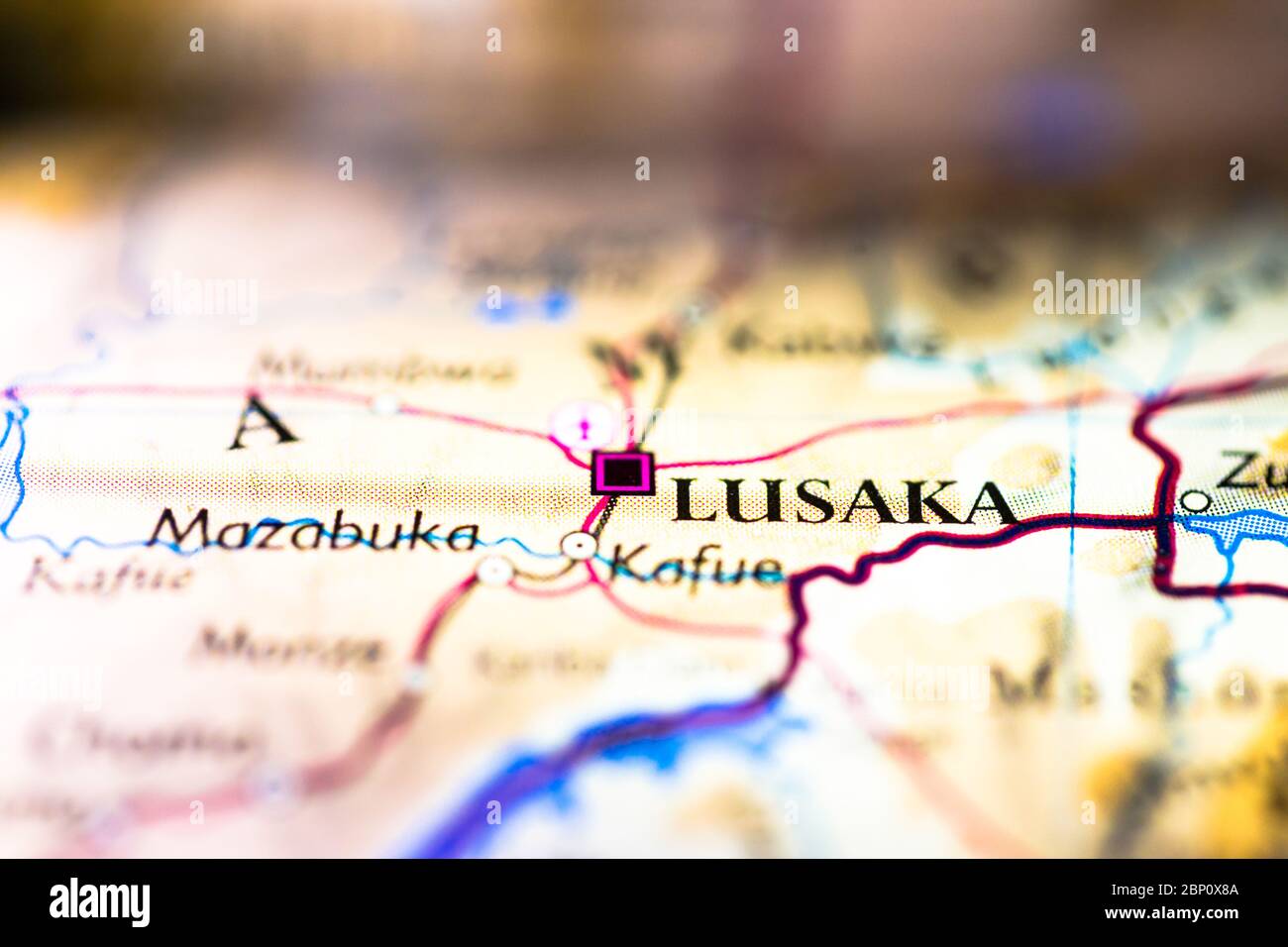 Profundidad reducida del campo centrada en la ubicación del mapa geográfico de la ciudad de Lusaka en el continente africano de Zambia en el atlas Foto de stock