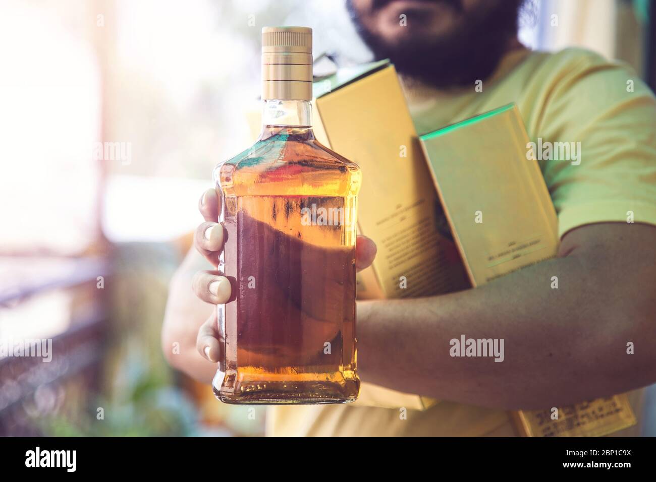 Primer plano de la mano del cliente mostrando la botella de licor de whisky cuando se va después de comprar licor de una tienda en medio de la continua cierre Covid-19 Foto de stock