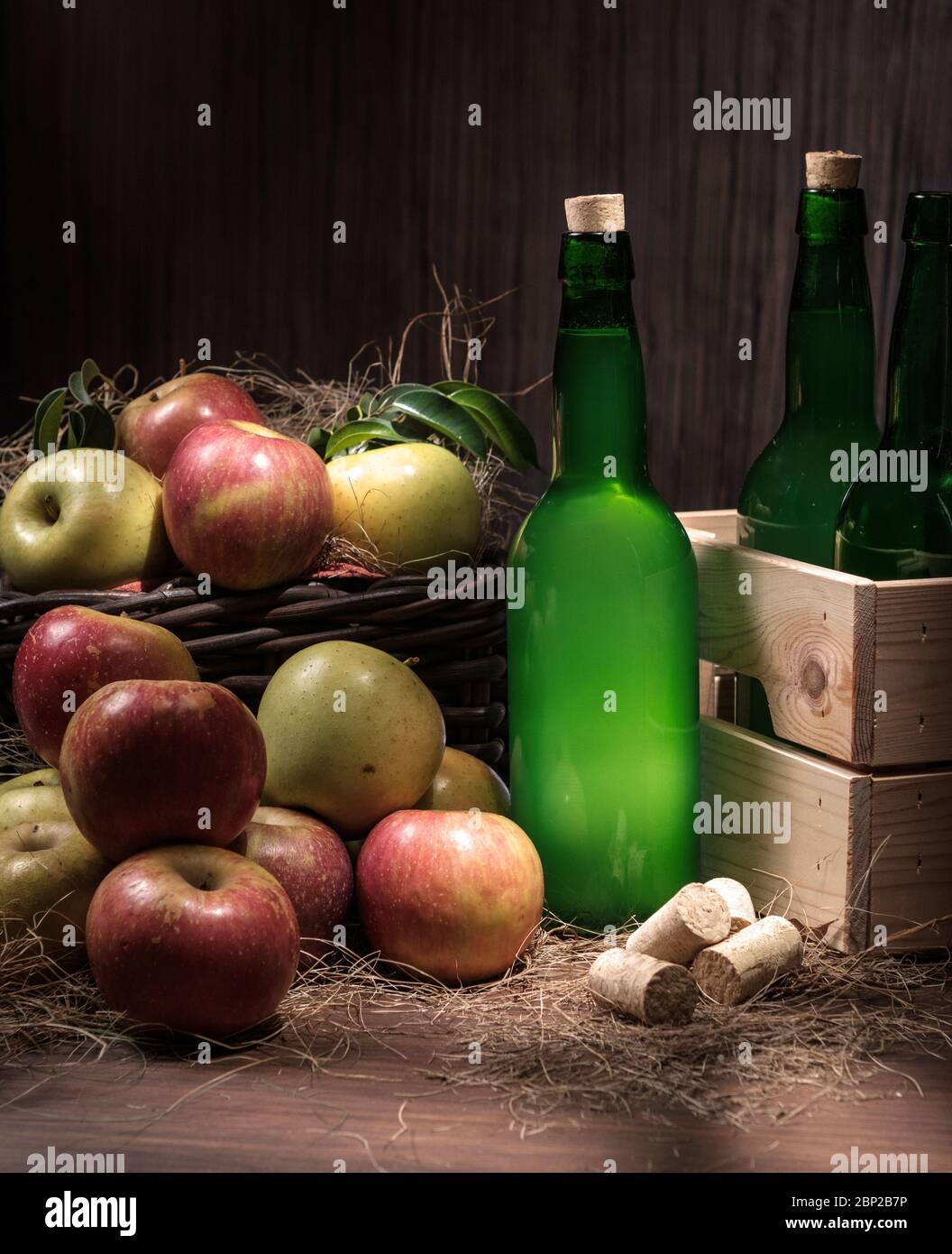 Botellas de sidra asturiana caja de madera con muchas manzanas rojas y  verdes en cesta de mimbre sobre fondo de madera Fotografía de stock - Alamy