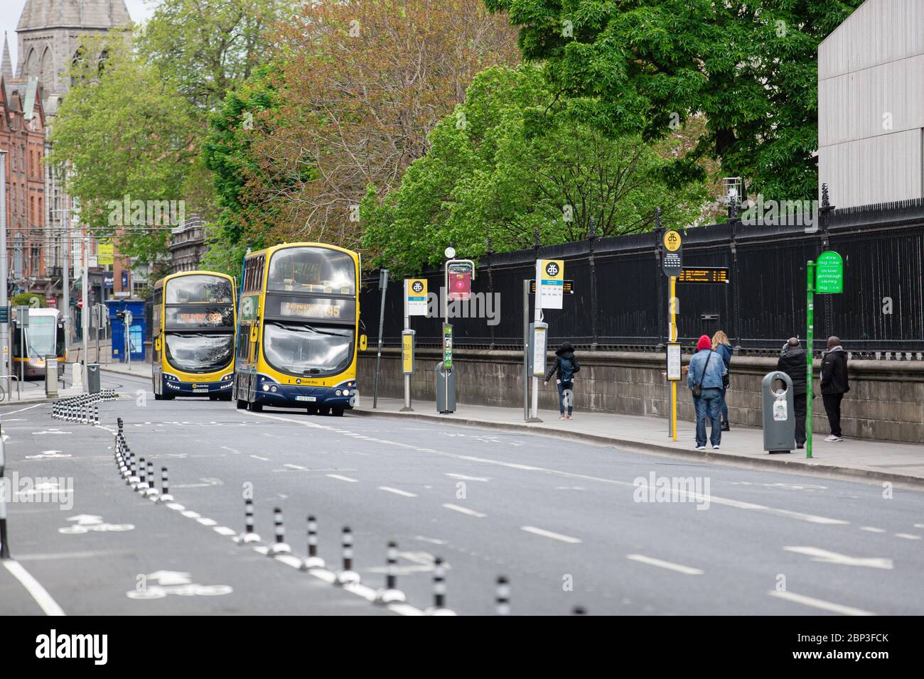 Dublín, Irlanda. Mayo de 2020. Autobuses de dos pisos de Dublín que se acercan a las paradas de autobús en Nassau Street. Viajeros que esperan un autobús. Transporte público. Foto de stock