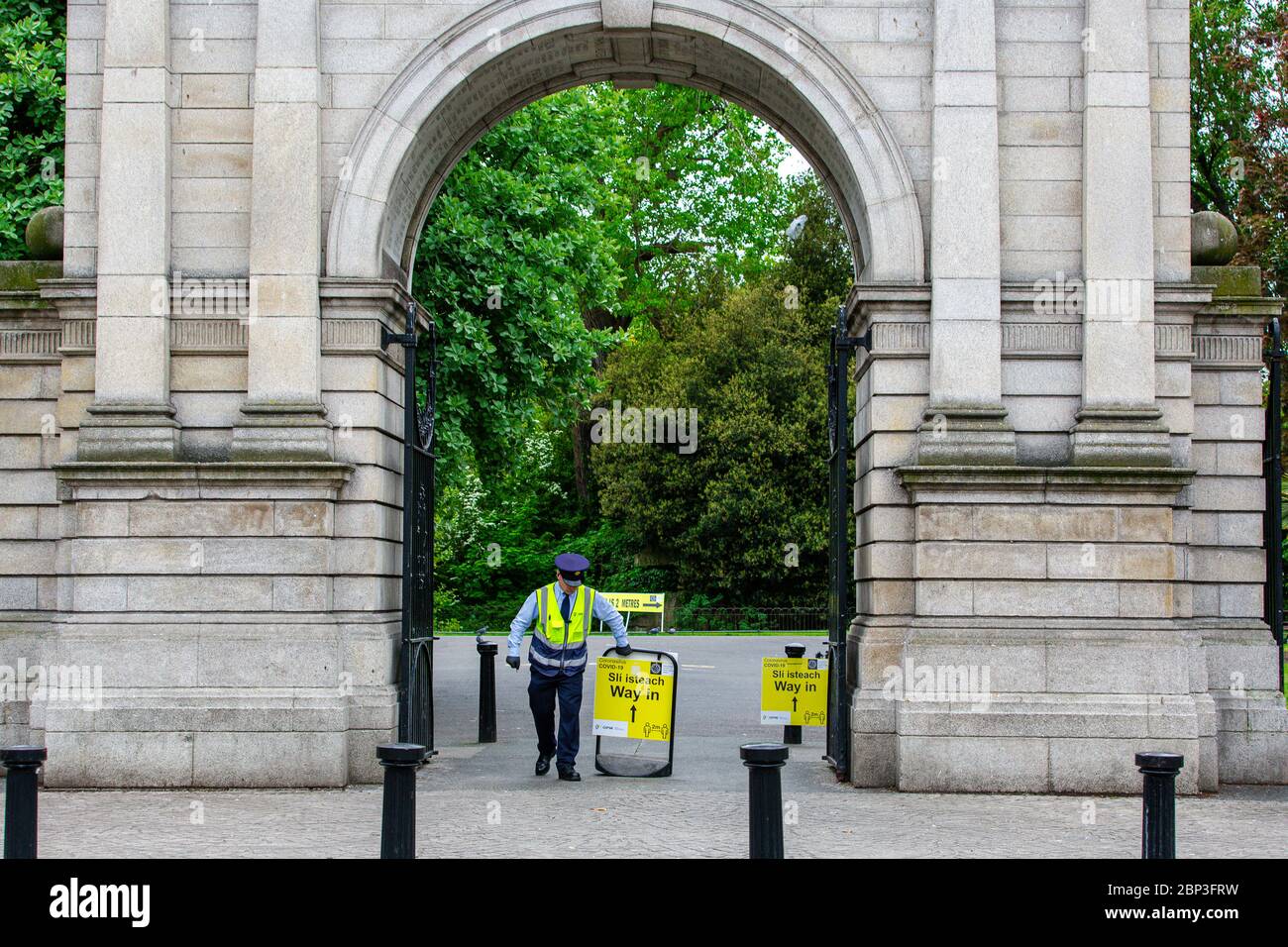 Dublín, Irlanda. Mayo de 2020. Alcaide estableciendo el cartel de seguridad Yellow Coronavirus Covid-19 en la entrada del Parque Verde de San Esteban en Dublín. Foto de stock