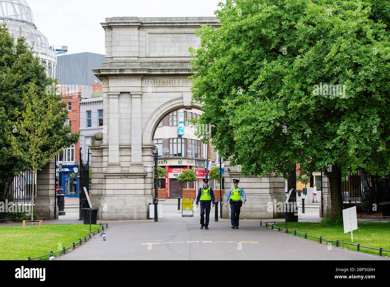 Dublín, Irlanda. Mayo de 2020. Dos Gardai patrullando por el Parque Verde de San Esteban a través de Fusiliers Arch. Cierre de Covid-19 en Dublín. Foto de stock