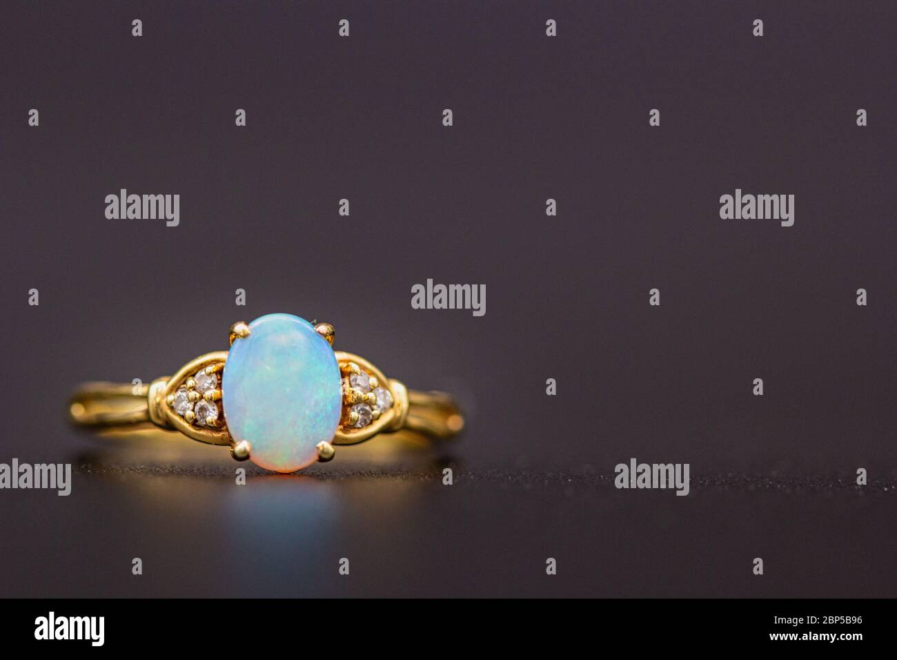 Un anillo de bodas de oro, diamante y ópalo. Foto de stock