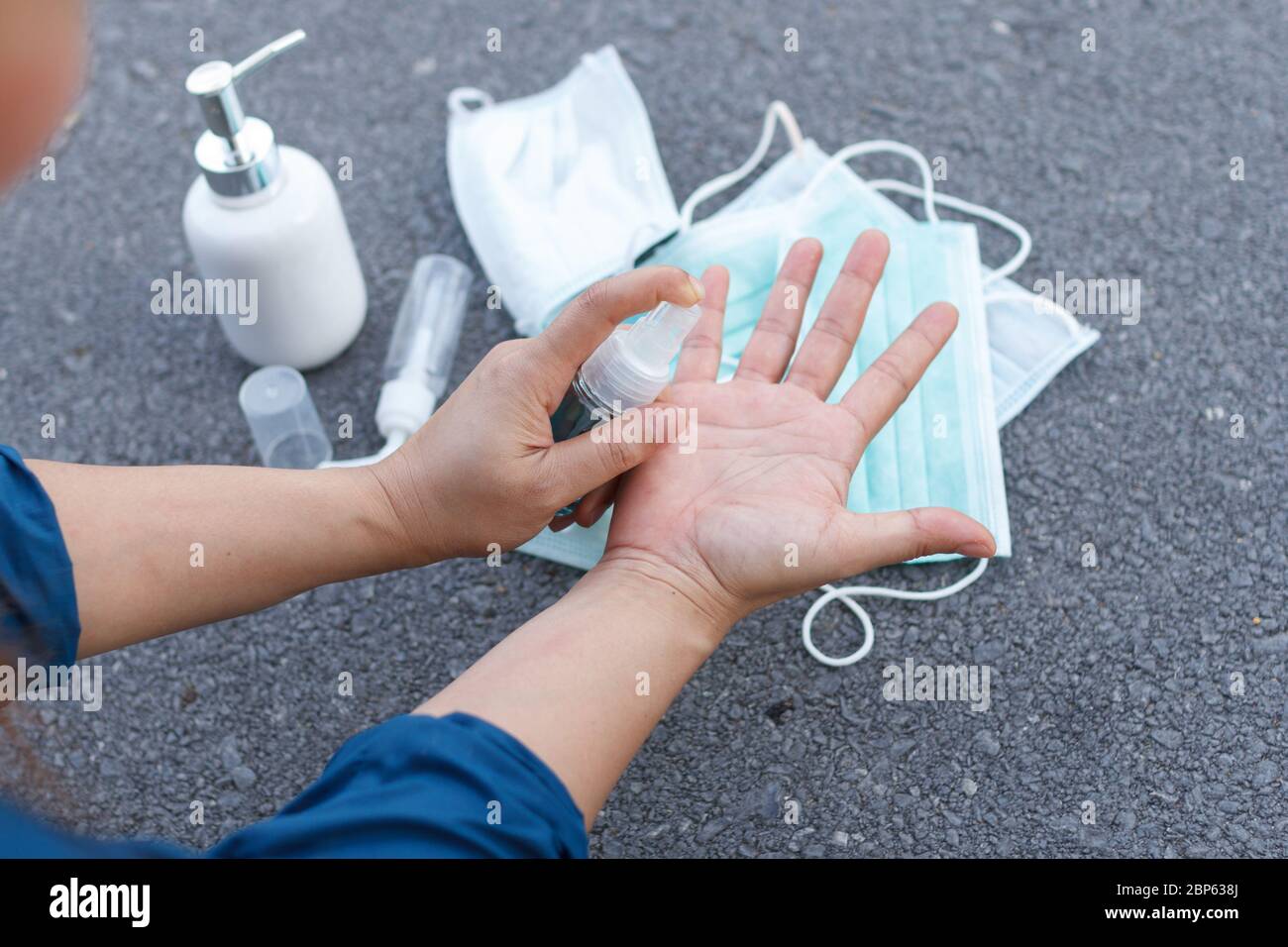 La mujer usa alcohol para limpiar las manos para prevenir el brote del virus coronavirus. COIVD 19 Foto de stock