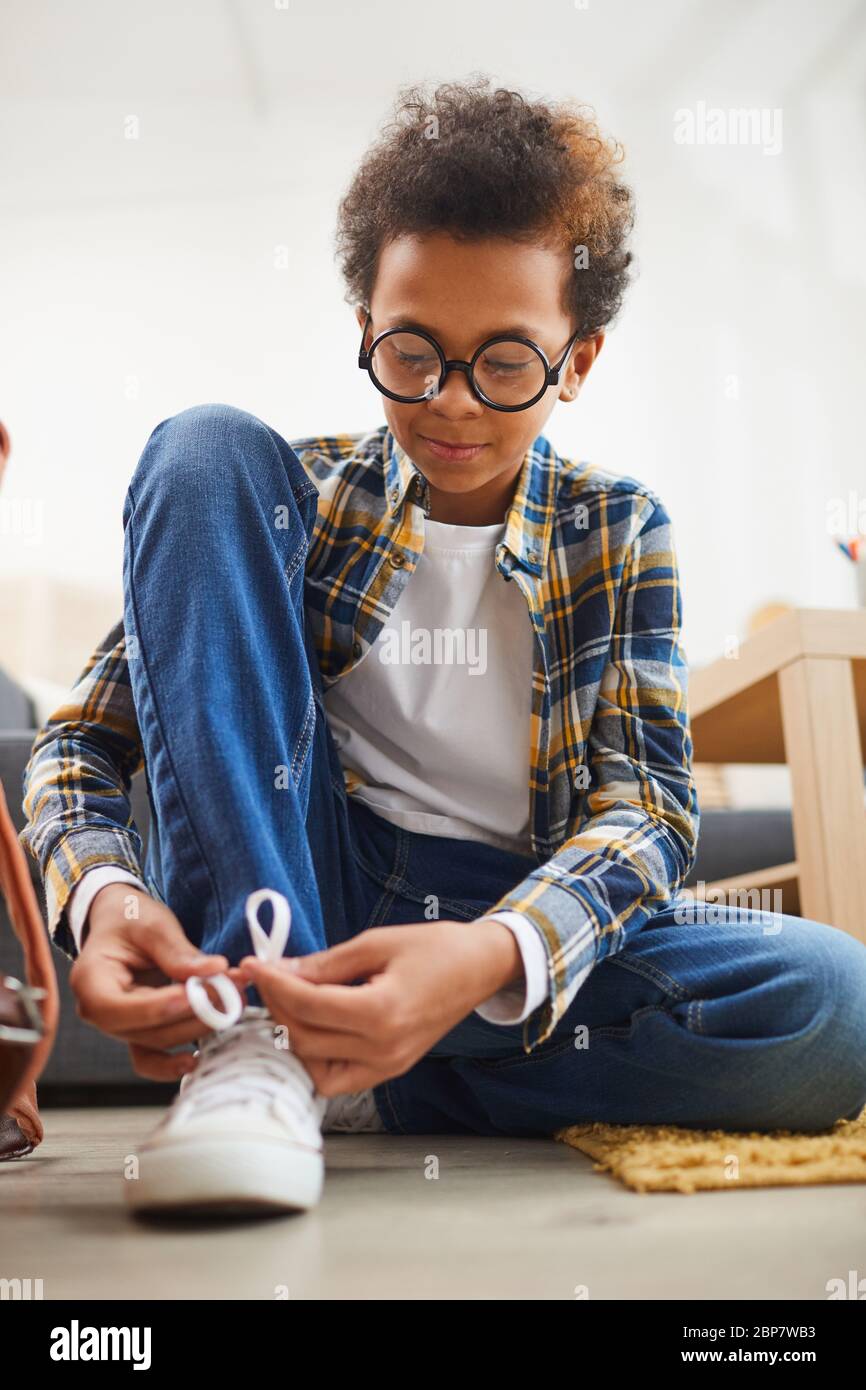 Retrato completo de un lindo niño afroamericano con gafas y zapatos de amarre Foto de stock