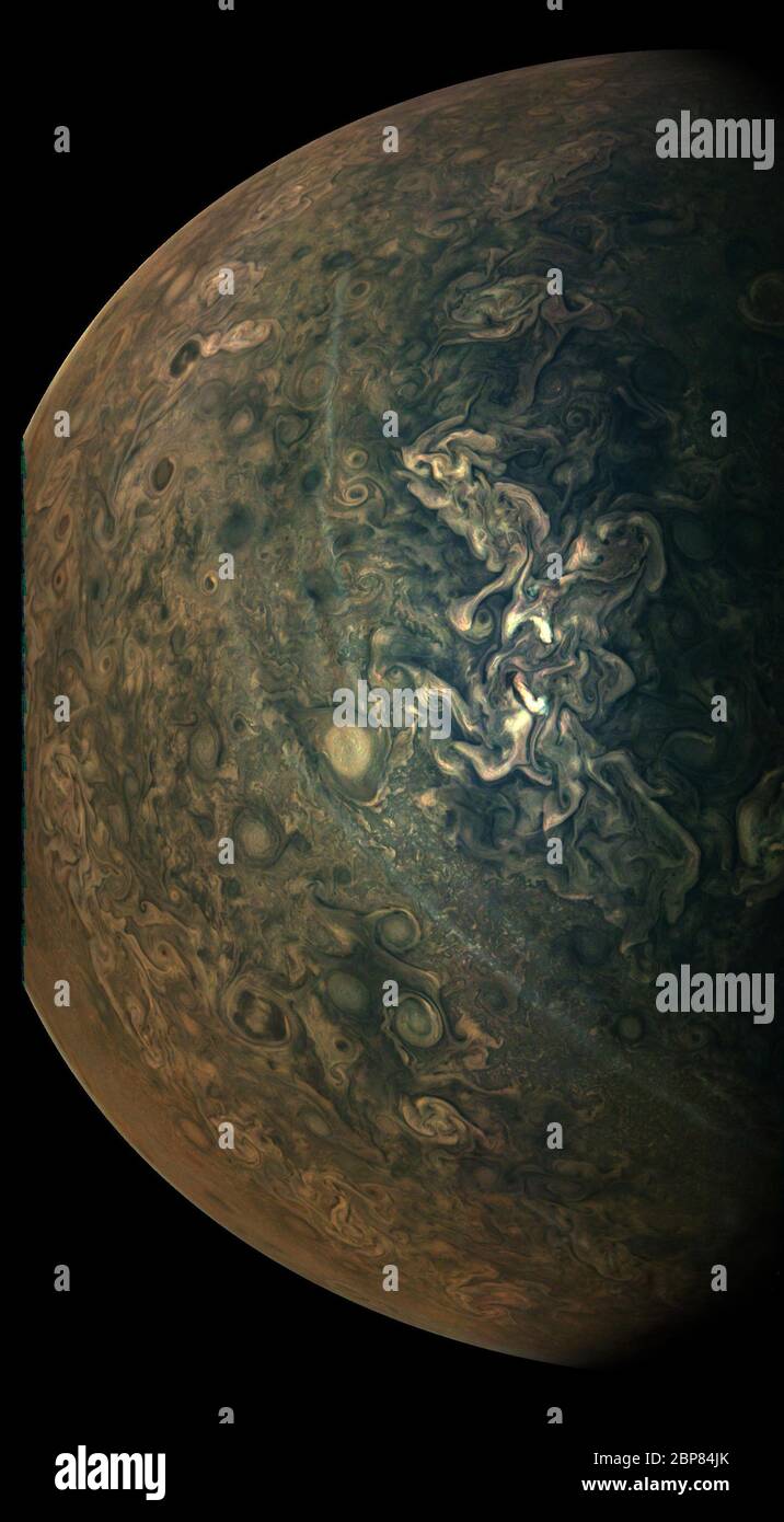 La misión Juno de la NASA capturó esta mirada a las tumultuosas regiones del norte de Júpiter durante el acercamiento de la nave espacial al planeta el 17 de febrero de 2020. Características notables en esta vista son las largas y delgadas bandas que recorren el centro de la imagen de arriba a abajo. Juno ha observado estas largas vetas desde su primer paso cercano por Júpiter en 2016. Las rayas son capas de partículas de neblina que flotan por encima de las características de la nube subyacente. Los científicos todavía no saben exactamente de qué están hechos estos hazes o cómo se forman. Dos chorros de agua en la atmósfera de Júpiter flanquean cada lado de la región w Foto de stock