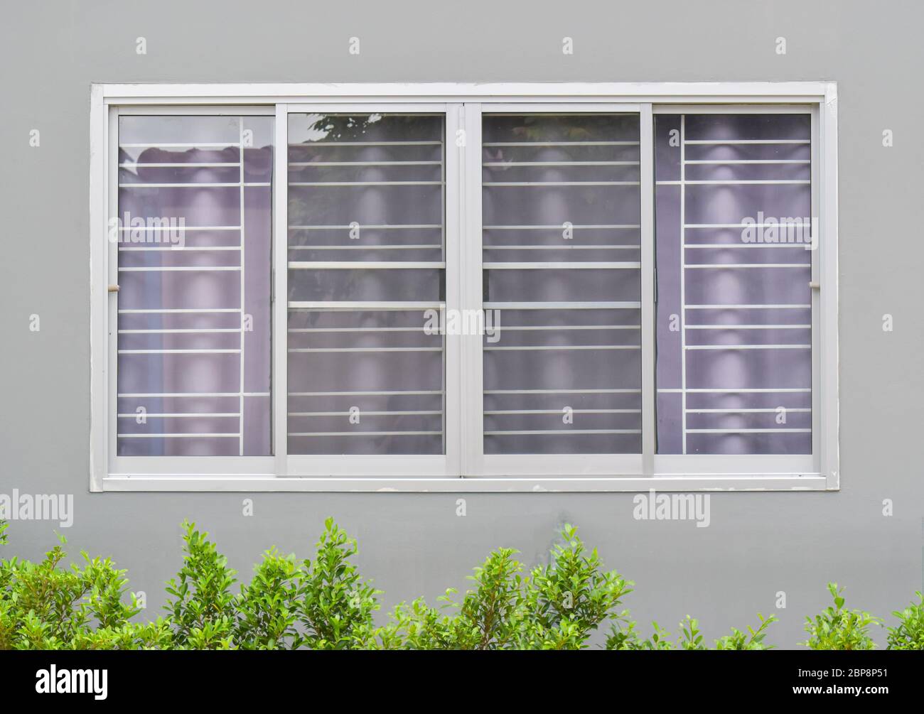 Ventanas modernas con cortina uv y pared gris de la casa desde la vista exterior Foto de stock