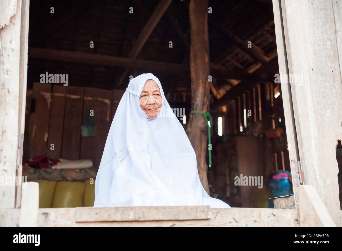 Un retrato de un anciano del pueblo que llevaba una túnica blanca en un pueblo rural de Cham. Camboya Central, Sudeste Asiático Foto de stock