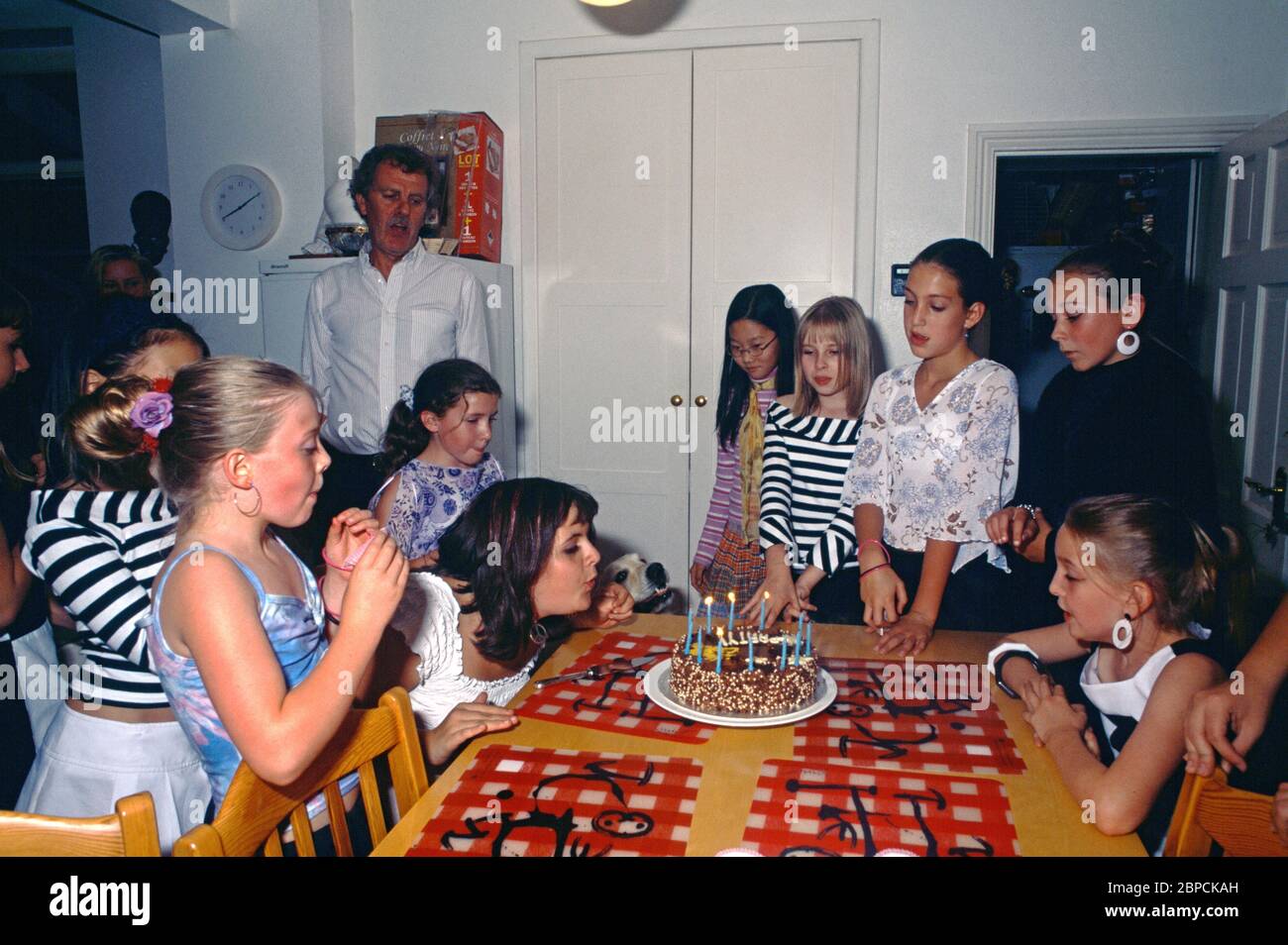 Doce años de antigüedad soplando velas en la torta en Birthday Party