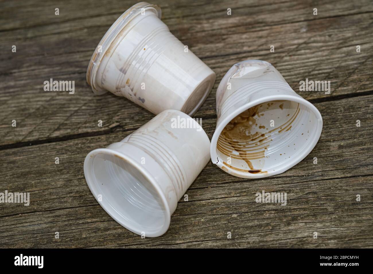 Saque las tazas usadas de café de plástico desechadas, la contaminación desechable sucia Foto de stock