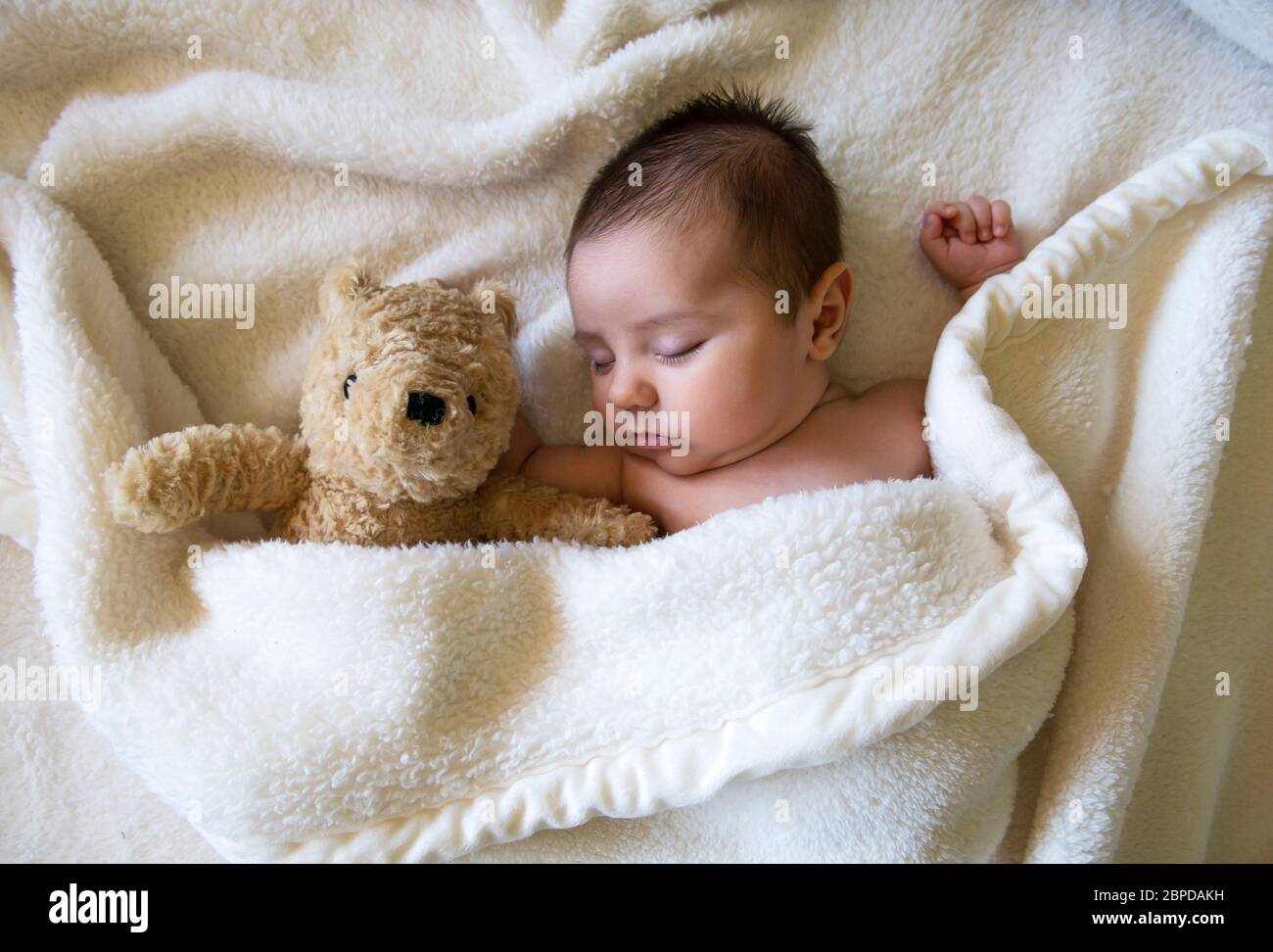 Recién nacido bebé niño durmiendo con oso de peluche Foto de stock