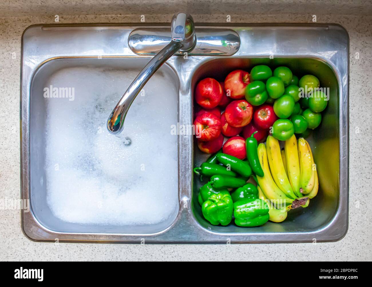 Lavar verduras y frutas en un canto con agua corriente y jabón Fotografía  de stock - Alamy