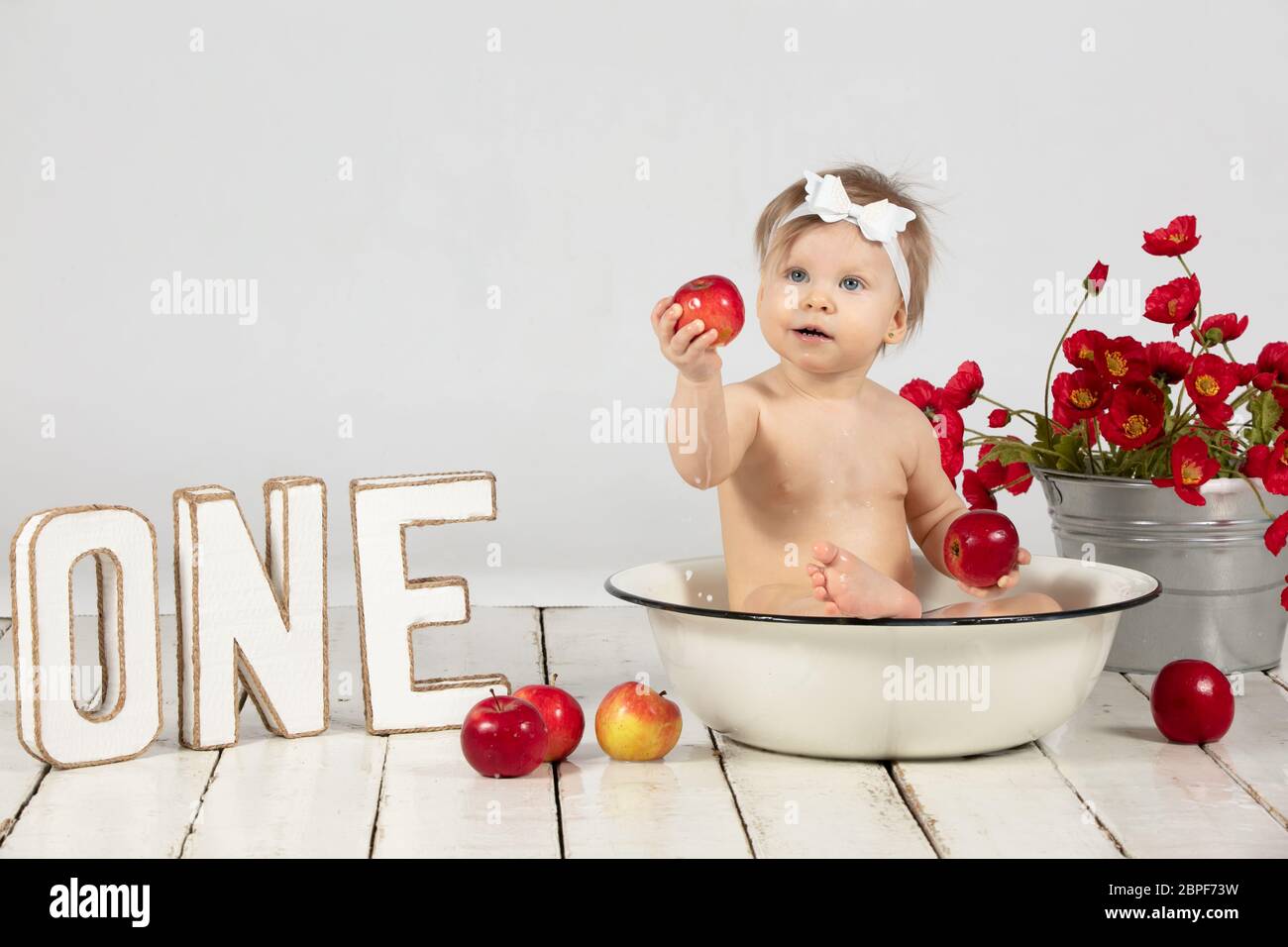 Un Bebe Hermoso Se Bana En Un Lavabo Y Come Una Manzana Roja Nina De Un Ano Fotografia De Stock Alamy