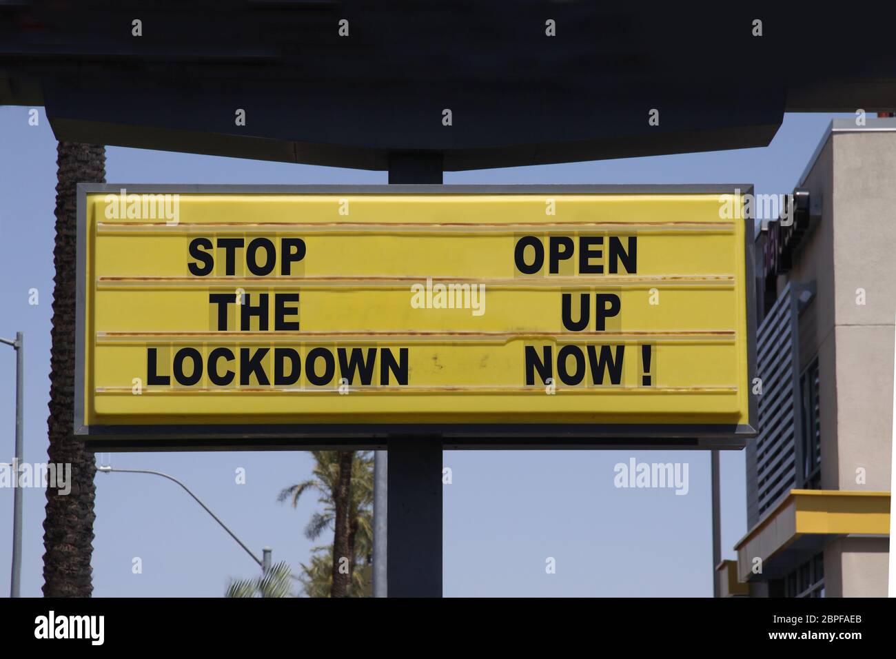 Billboard diciendo: ¡Pare el bloqueo - ¡abra ahora! con palmeras y fondo azul cielo. Protestas contra el cierre de la cárcel. Foto de stock