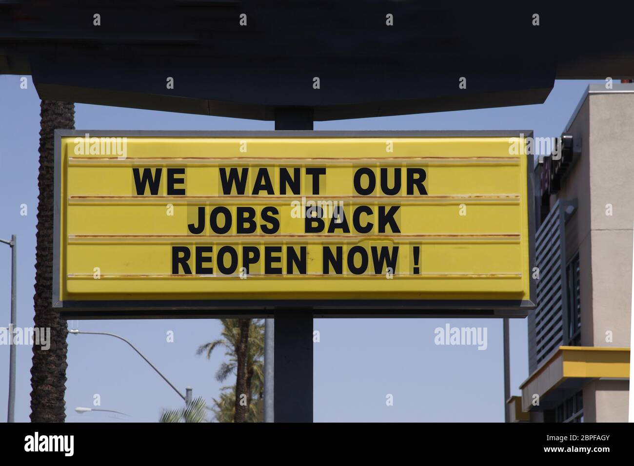 Billboard diciendo que queremos nuestros trabajos Volver reabrir ahora con palmeras y fondo azul cielo. Protestas contra el cierre de la cárcel. Foto de stock
