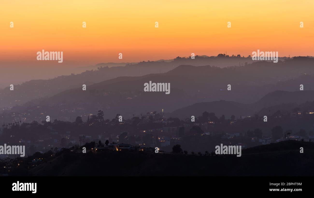 Puesta de sol sobre las colinas de Hollywood, los Ángeles. El cielo es de varios tonos de naranja y amarillo. Foto de stock